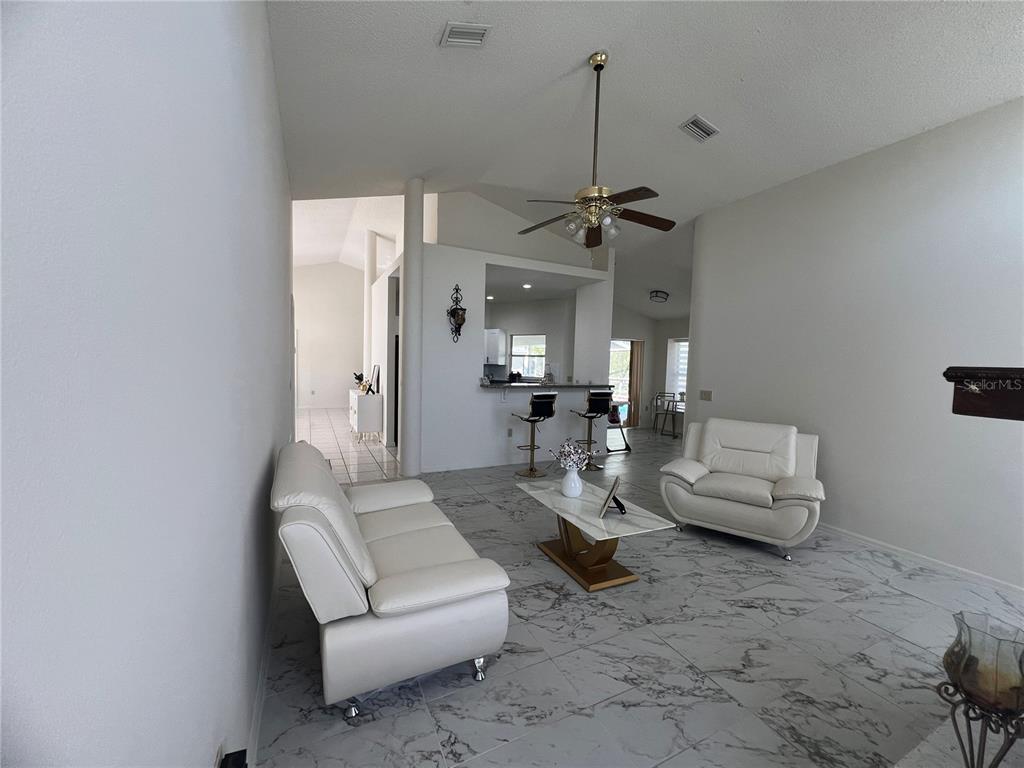 14189 Cornewall Lane Spring Hill, FL 34609 - Photo 10 of 36 a living room with furniture and a chandelier