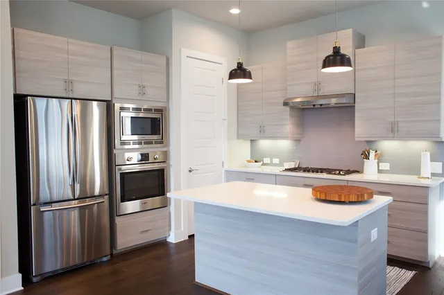 a kitchen with stainless steel appliances a refrigerator and a stove
