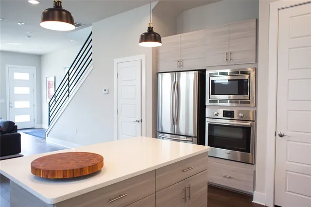 a kitchen with kitchen island granite countertop a sink stove and refrigerator