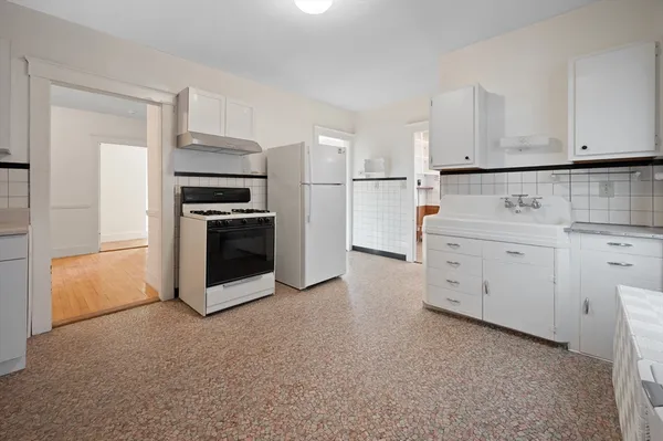 a kitchen with stainless steel appliances granite countertop a refrigerator sink and white cabinets