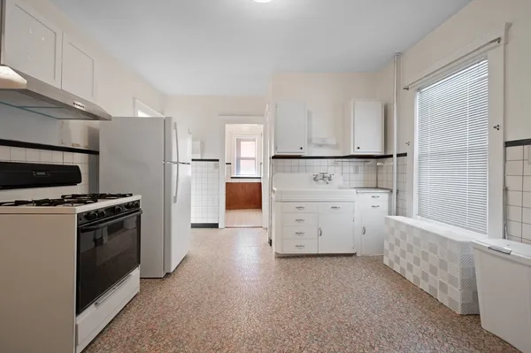 a kitchen with white cabinets and white appliances