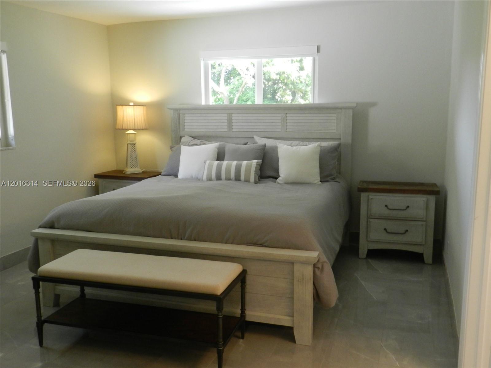305 Northwest 42nd Street Boca Raton, FL 33431 - Photo 12 of 31 a bedroom with a bed and a lamp