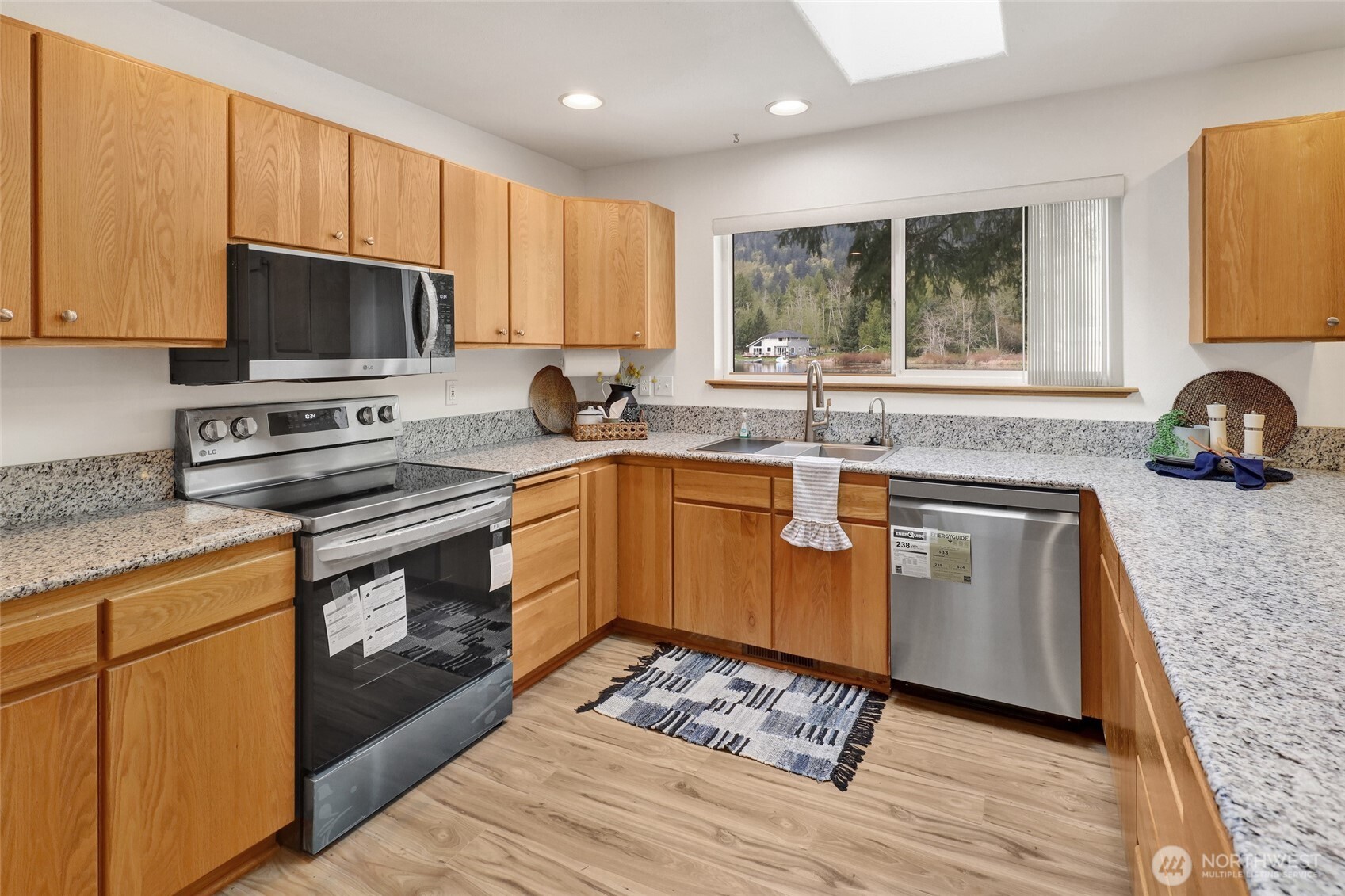 659 Cain Lake Road Sedro-Woolley, WA 98284 - Photo 18 of 40 a kitchen with stainless steel appliances granite countertop a stove a sink dishwasher a microwave oven and a refrigerator with wooden cabinets