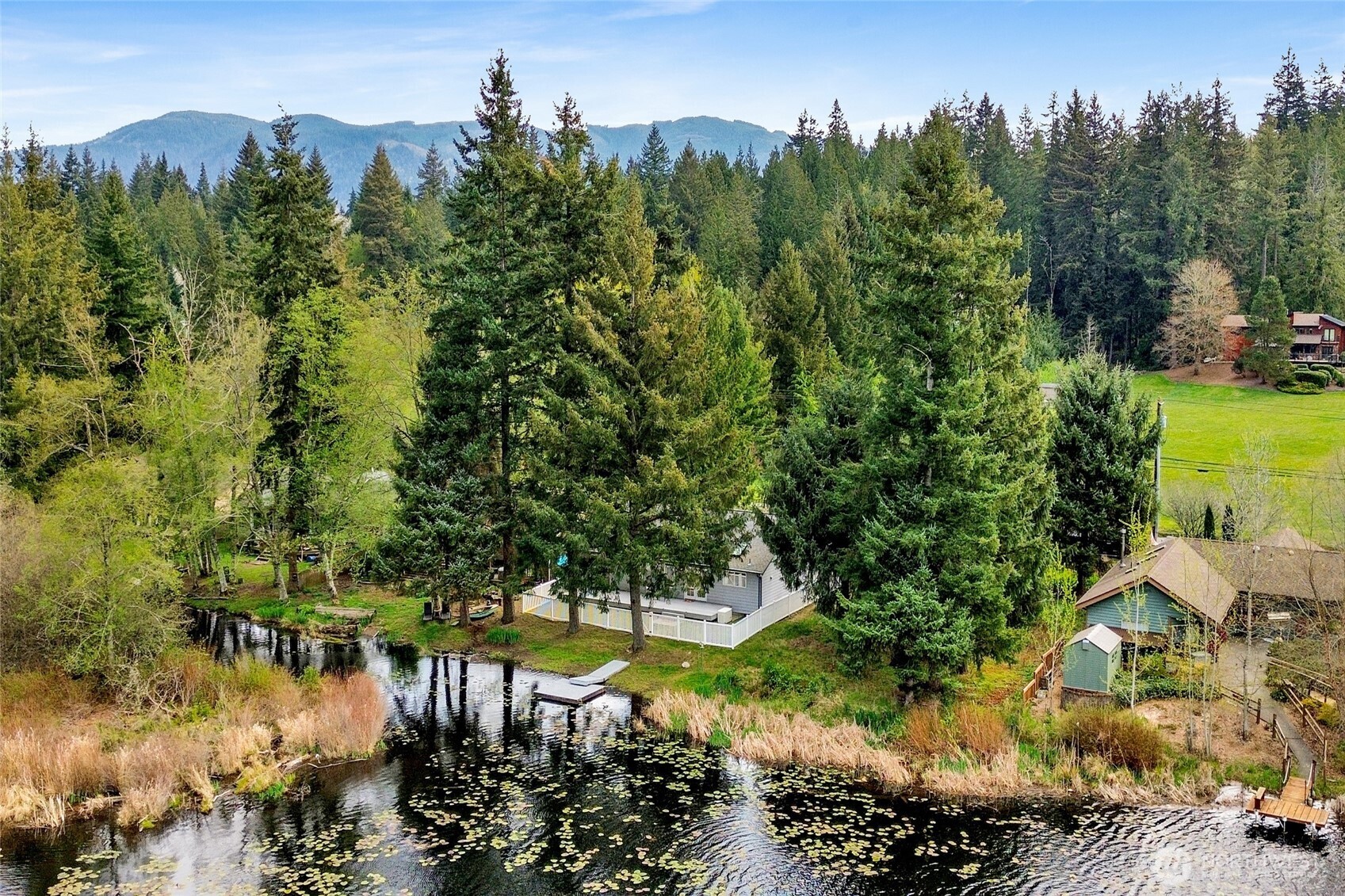 659 Cain Lake Road Sedro-Woolley, WA 98284 - Photo 6 of 40 a view of a lake with a house in the background