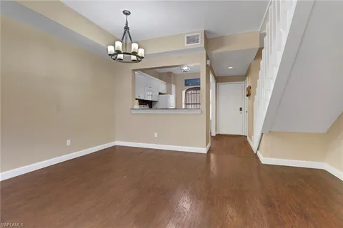 a view of a room with wooden floor chandelier and entryway