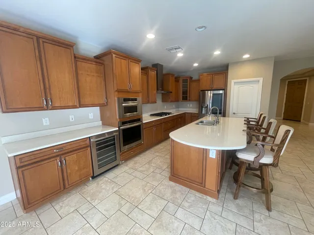 a kitchen with kitchen island granite countertop a sink a counter top space appliances and cabinets