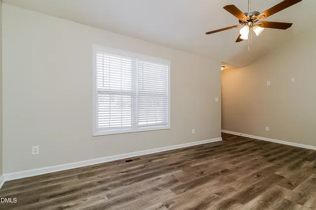 a view of an empty room with a window and a ceiling fan