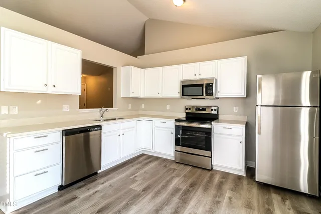 a kitchen with cabinets stainless steel appliances and a window