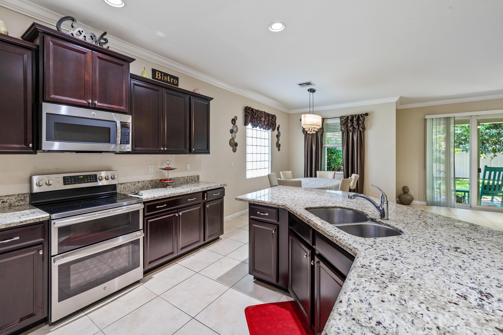 7034 Limestone Cay Road Jupiter, FL 33458 - Photo 11 of 43 a kitchen with stainless steel appliances granite countertop a sink stove and refrigerator