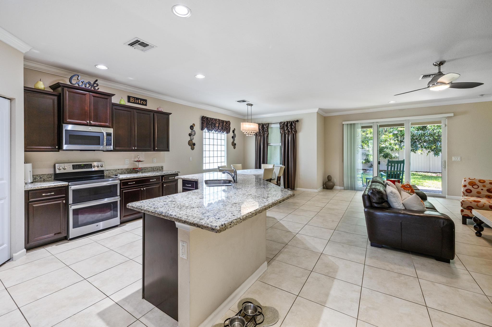 7034 Limestone Cay Road Jupiter, FL 33458 - Photo 42 of 43 a kitchen with stainless steel appliances granite countertop a sink dishwasher stove and refrigerator