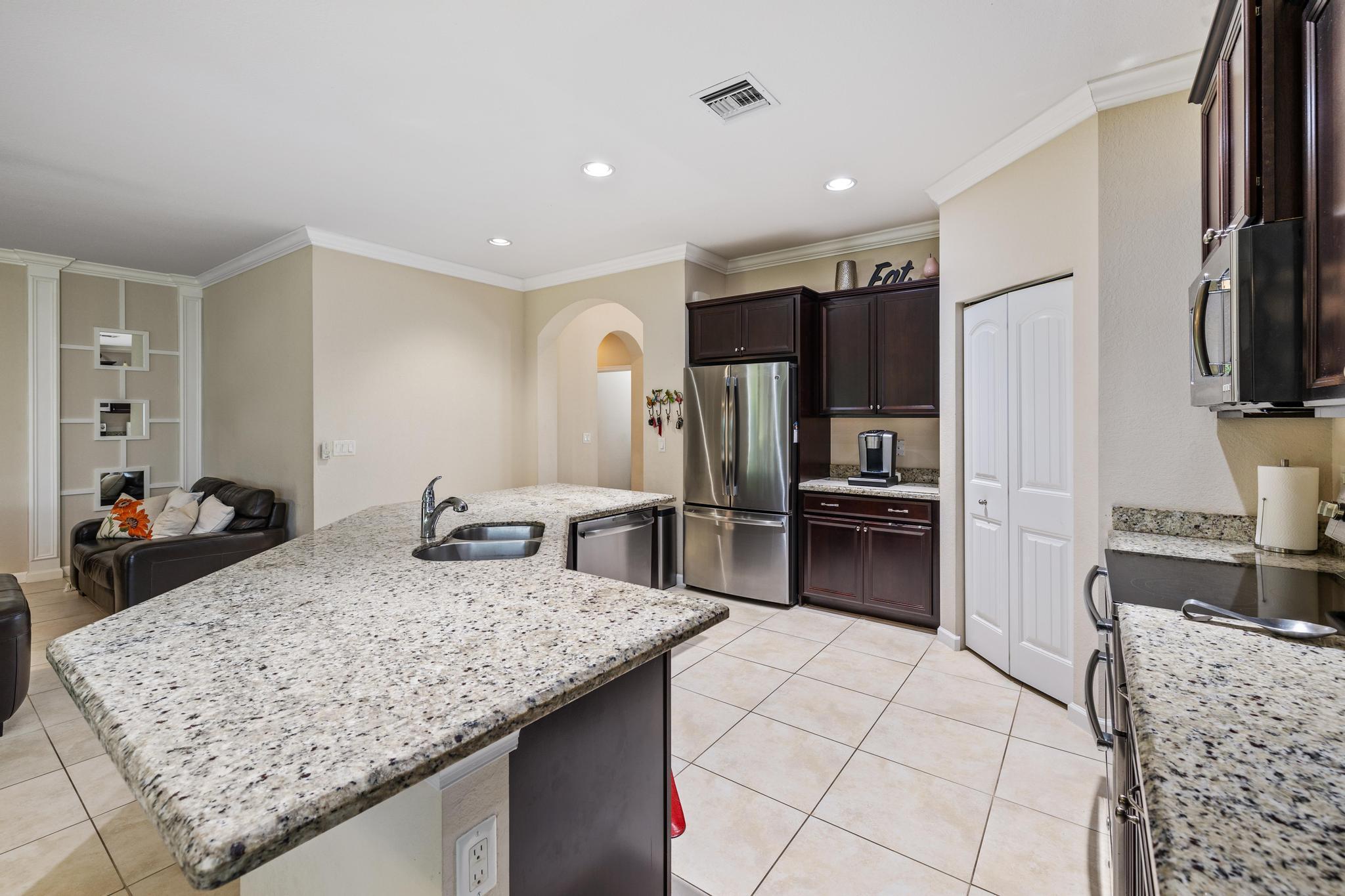 7034 Limestone Cay Road Jupiter, FL 33458 - Photo 17 of 43 a kitchen with stainless steel appliances granite countertop a sink stove and refrigerator