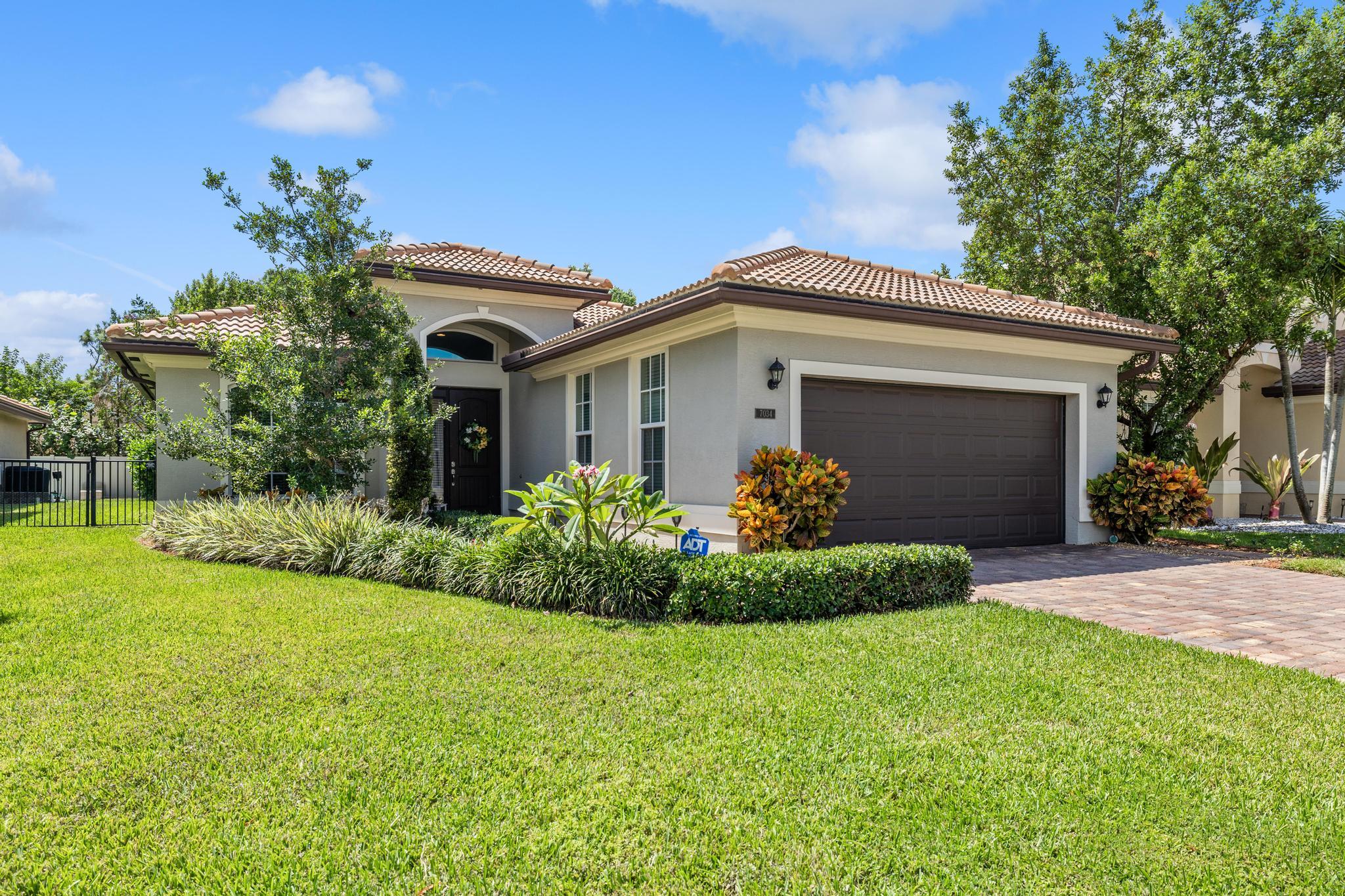 7034 Limestone Cay Road Jupiter, FL 33458 - Photo 2 of 43 a front view of a house with garden