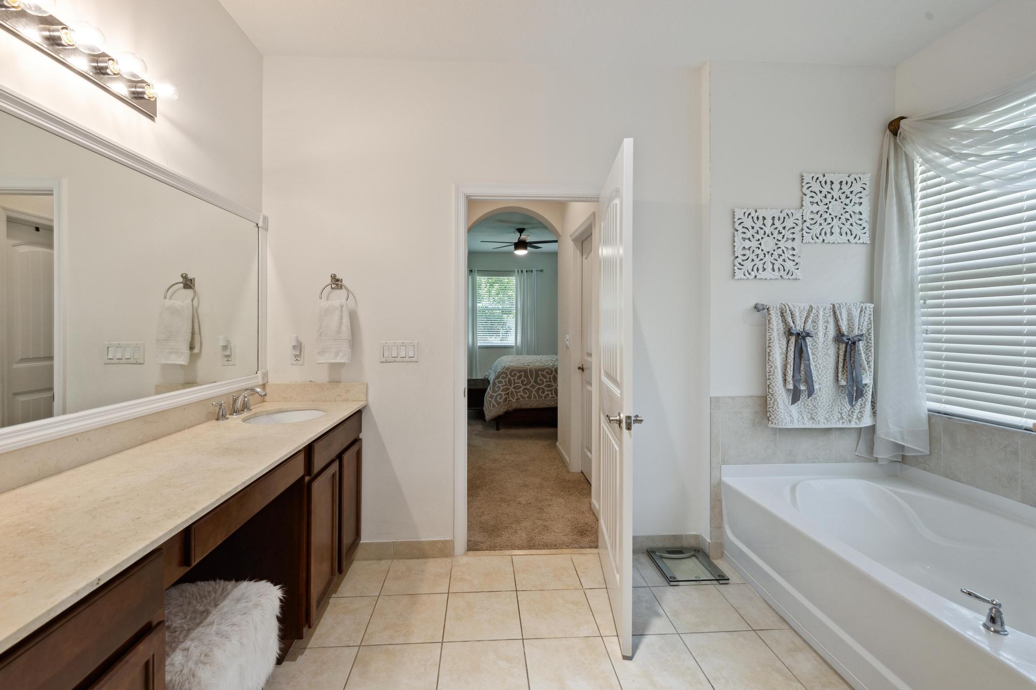 7034 Limestone Cay Road Jupiter, FL 33458 - Photo 27 of 43 a bathroom with a tub a sink and a mirror