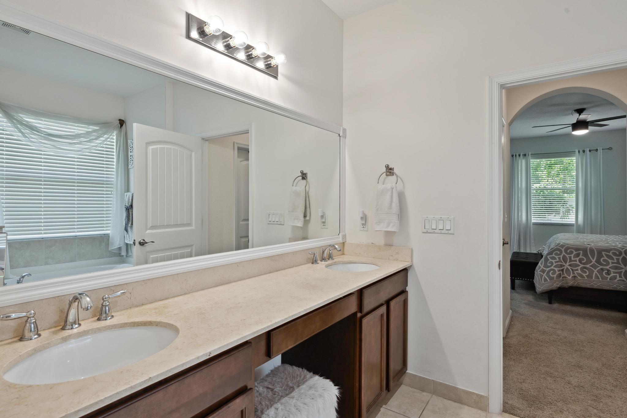 7034 Limestone Cay Road Jupiter, FL 33458 - Photo 28 of 43 a en suite bathroom with a double vanity sink and a mirror