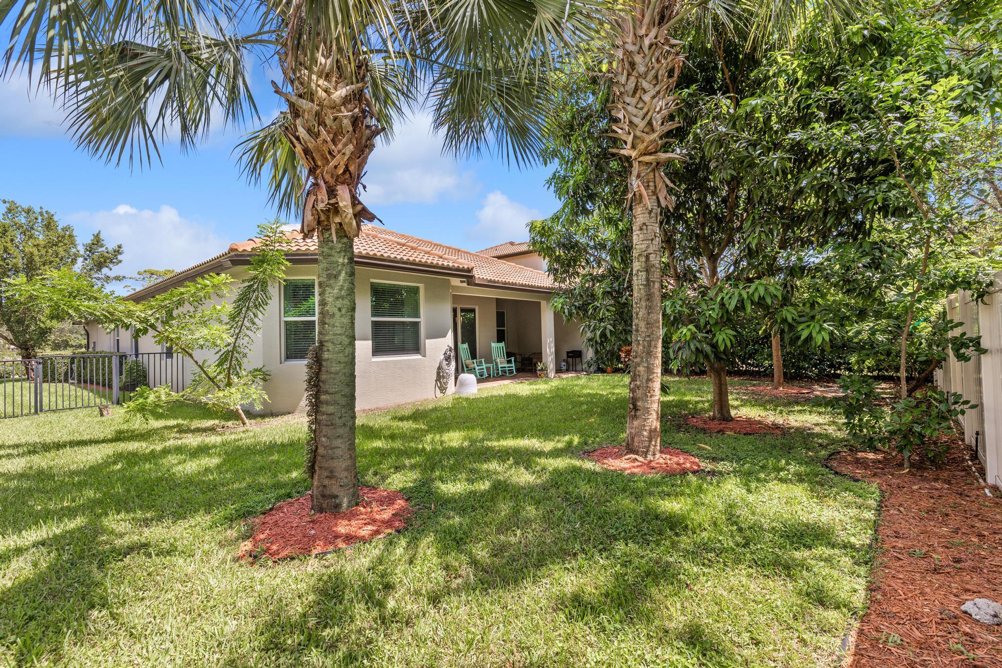 7034 Limestone Cay Road Jupiter, FL 33458 - Photo 32 of 43 a backyard of a house with table and chairs