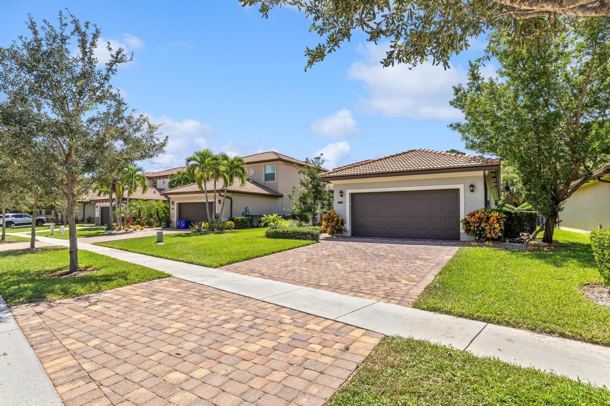 7034 Limestone Cay Road Jupiter, FL 33458 - Photo 5 of 43 a front view of a house with a yard and garage