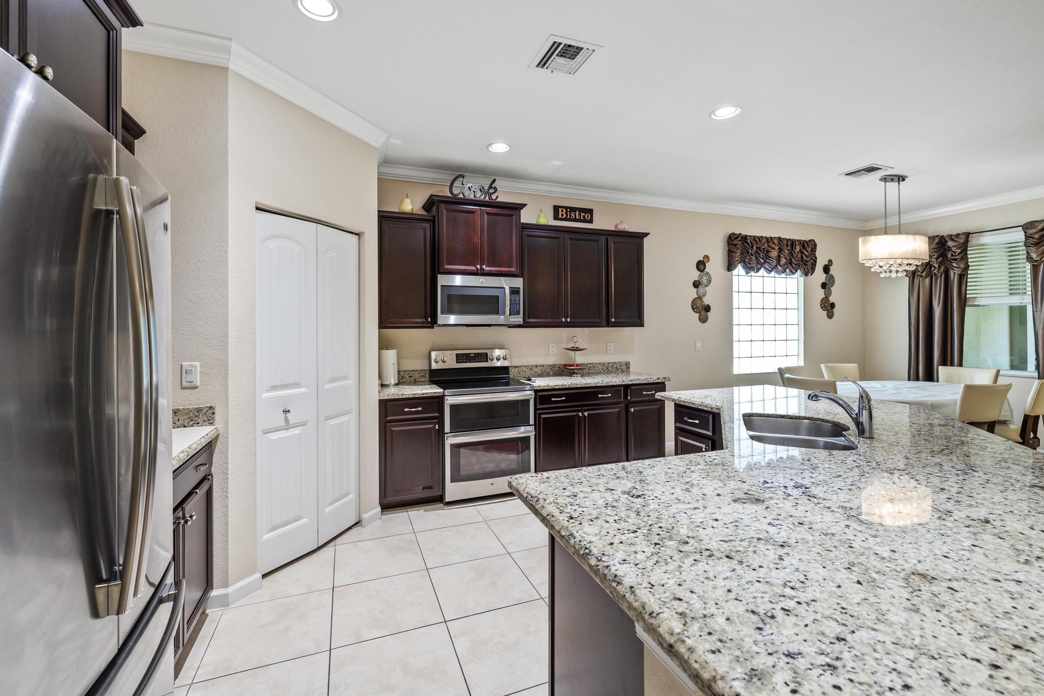 7034 Limestone Cay Road Jupiter, FL 33458 - Photo 10 of 43 a kitchen with stainless steel appliances granite countertop a refrigerator stove and oven