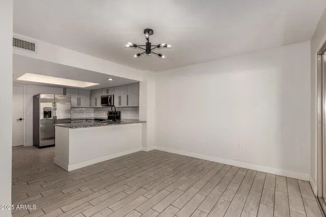 a kitchen with cabinets stainless steel appliances and a counter space