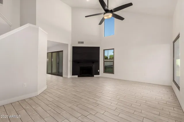 a view of an empty room with a fireplace and a window