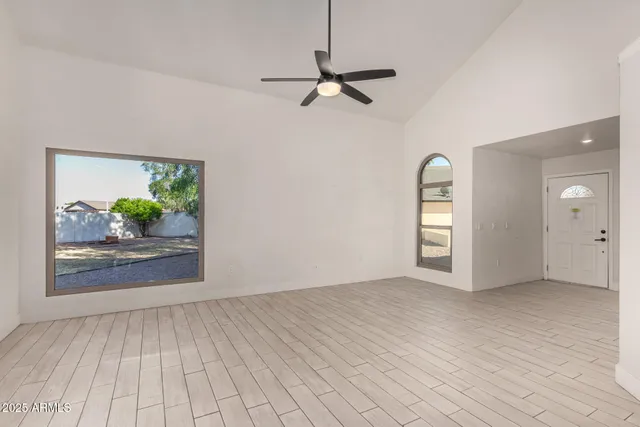 a view of a livingroom with wooden floor and a ceiling fan