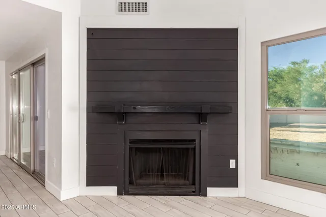 a view of empty room with window and wooden floor