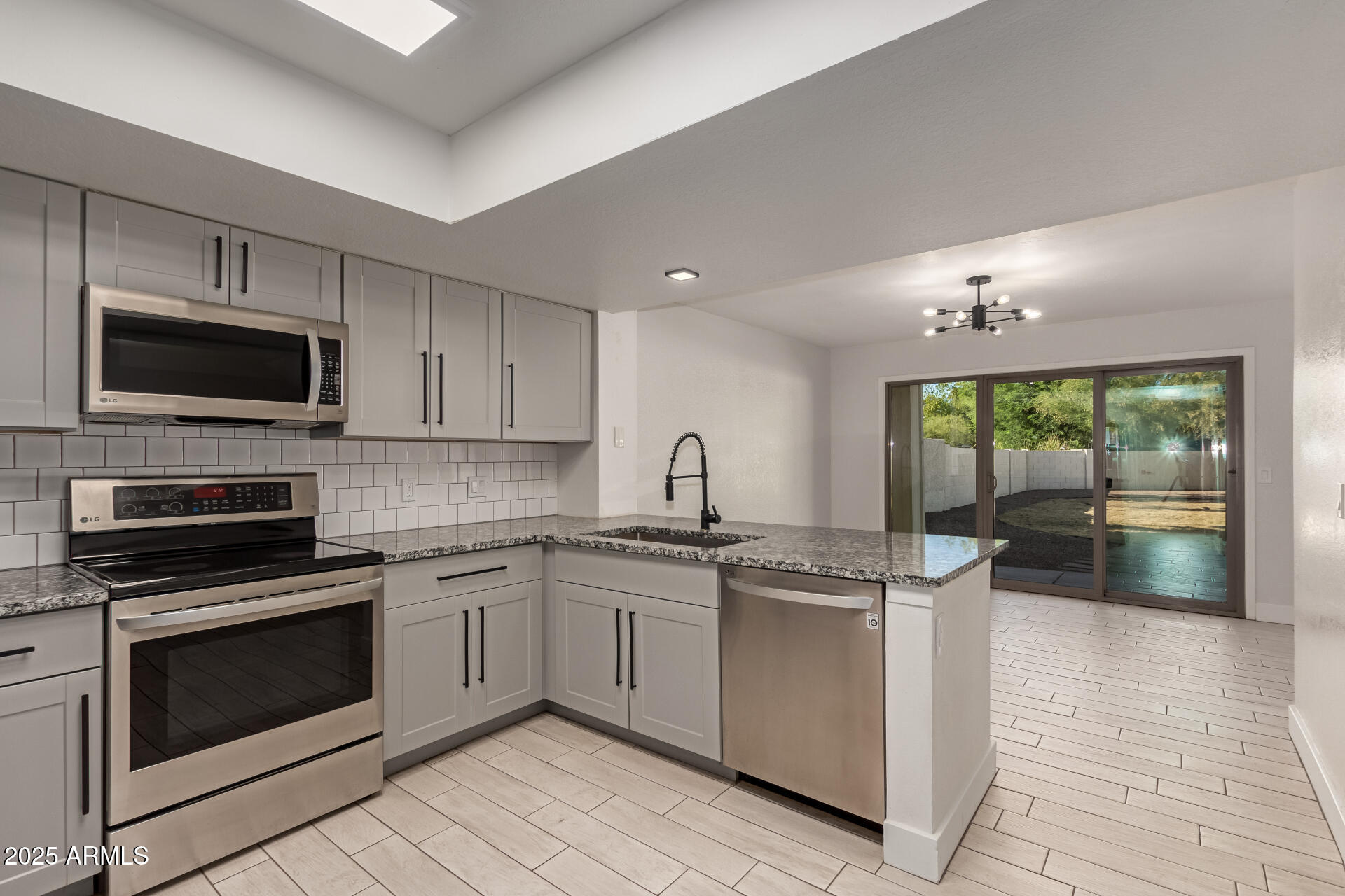 1621 North Chippewa Drive Chandler, AZ 85224 - Photo 6 of 25 a kitchen with kitchen island granite countertop a stove sink and microwave