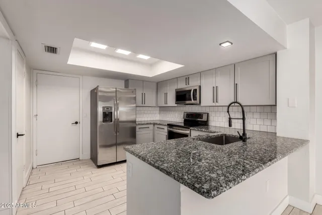 a view of a kitchen with a sink and wooden floor