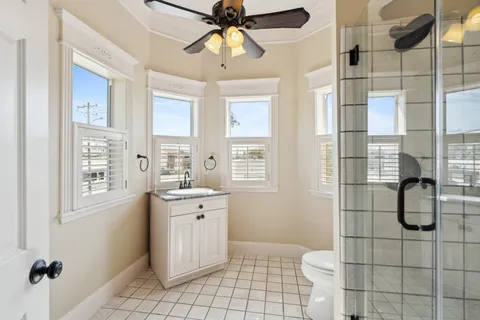 a bathroom with a granite countertop sink a toilet and shower