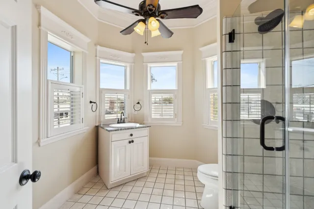 a bathroom with a granite countertop sink a toilet and shower