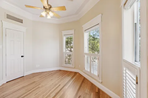 a view of an empty room with a window and wooden floor