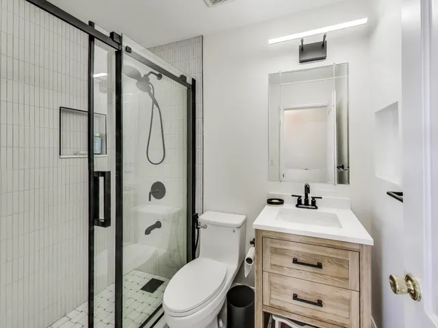 a bathroom with a sink a toilet and shower