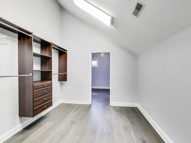 a view of walk in closet with empty racks