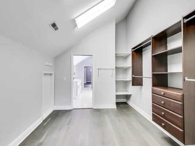 a view of walk in closet with empty racks