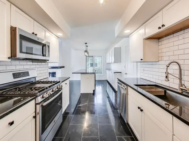 a kitchen with stainless steel appliances a sink stove and cabinets