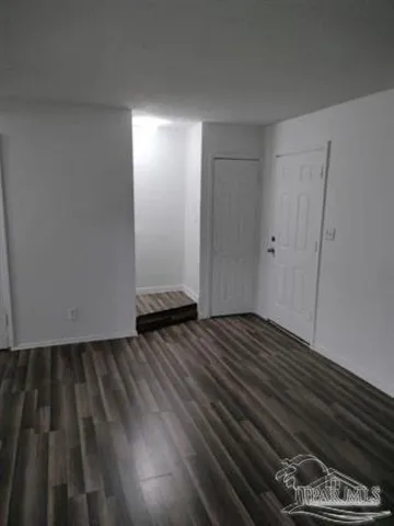 a view of an empty room and wooden floor