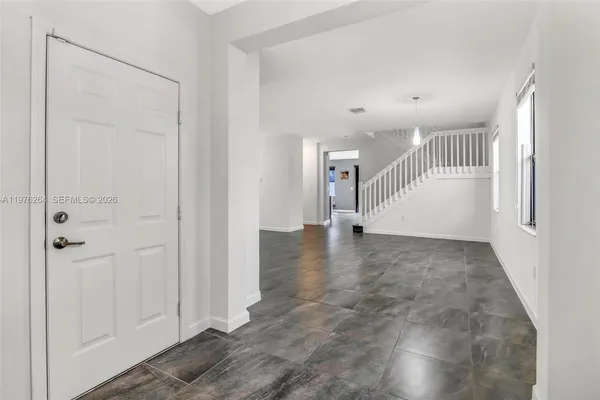 a view of a livingroom with wooden floor and a bathroom