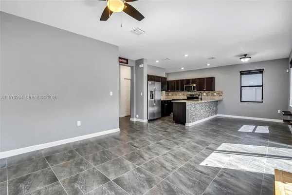 a view of a room with wooden floor and a ceiling fan