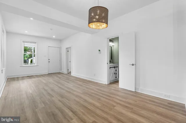 a view of empty room with wooden floor and window