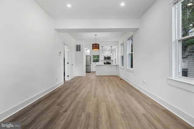 a view of a big room with wooden floor and windows