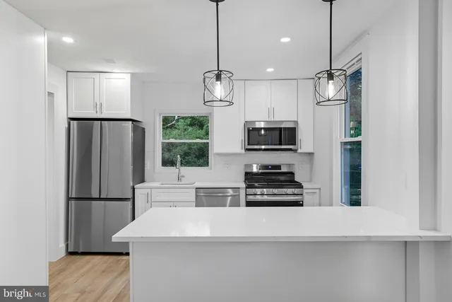 a kitchen with stainless steel appliances a refrigerator and a stove top oven