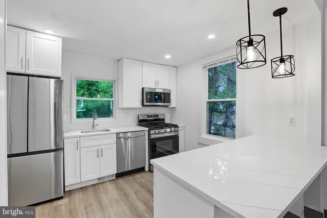 a kitchen with white cabinets and stainless steel appliances