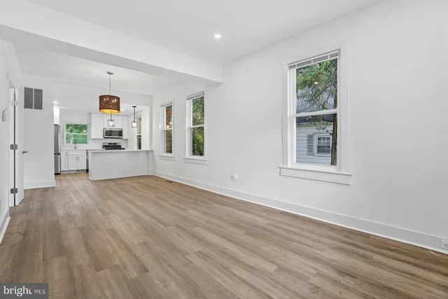 a view of a livingroom with wooden floor and furniture