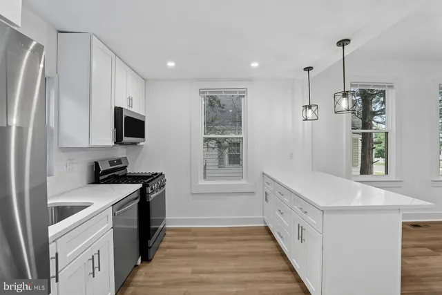 a kitchen with granite countertop a sink stove and refrigerator