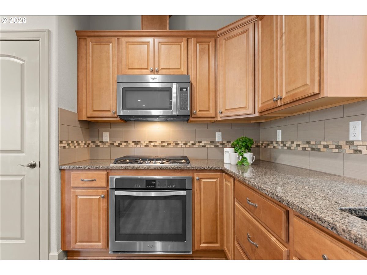 10899 Southwest Barber Street Wilsonville, OR 97070 - Photo 11 of 44 a kitchen with granite countertop cabinets stainless steel appliances and a sink