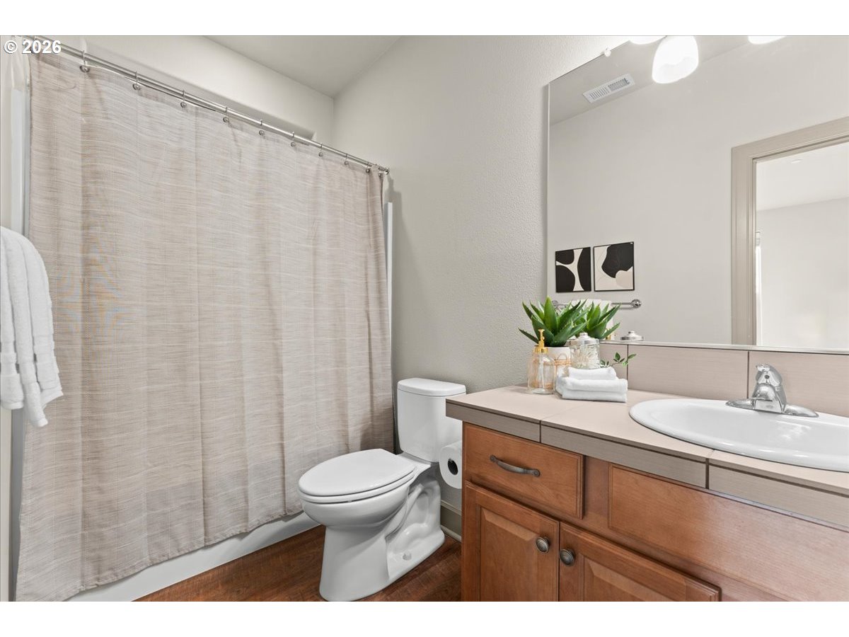 10899 Southwest Barber Street Wilsonville, OR 97070 - Photo 17 of 44 a bathroom with a sink a toilet and shower curtain