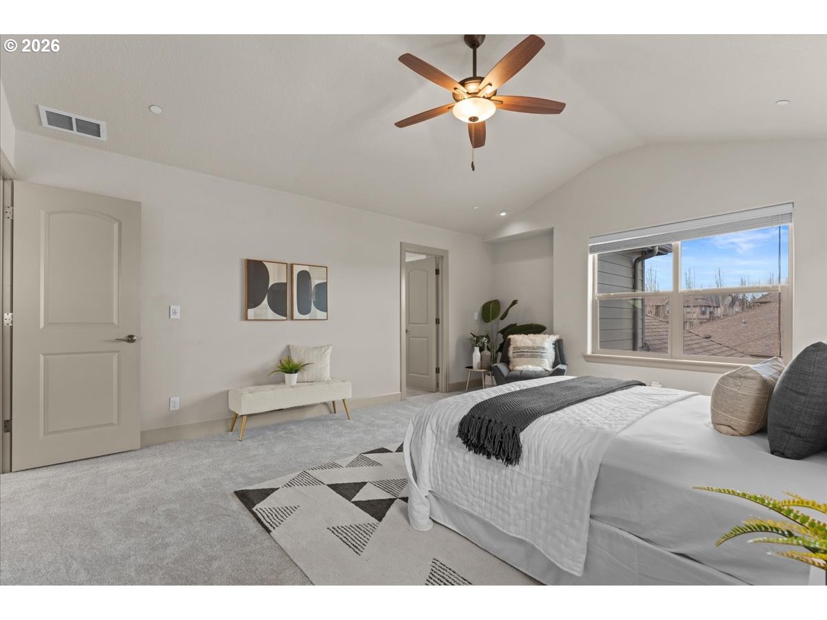 10899 Southwest Barber Street Wilsonville, OR 97070 - Photo 20 of 44 a bedroom with a large bed and a chandelier