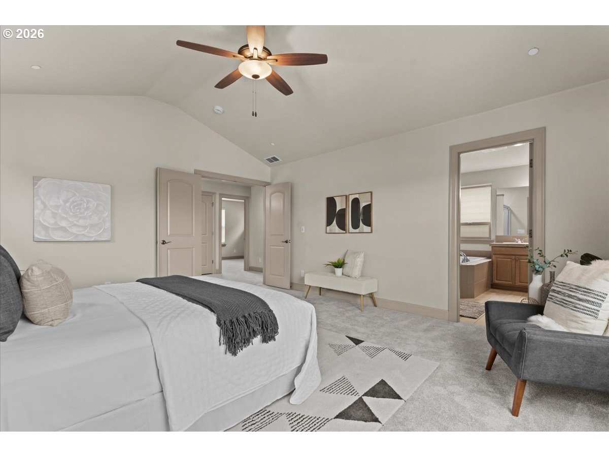 10899 Southwest Barber Street Wilsonville, OR 97070 - Photo 21 of 44 a bedroom with a large bed and a chandelier