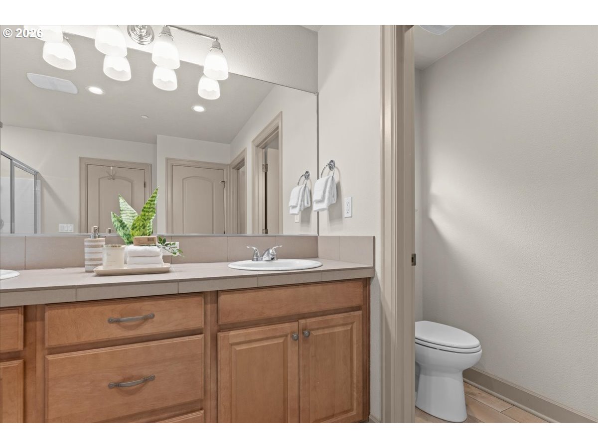 10899 Southwest Barber Street Wilsonville, OR 97070 - Photo 25 of 44 a bathroom with a granite countertop sink a toilet and a mirror