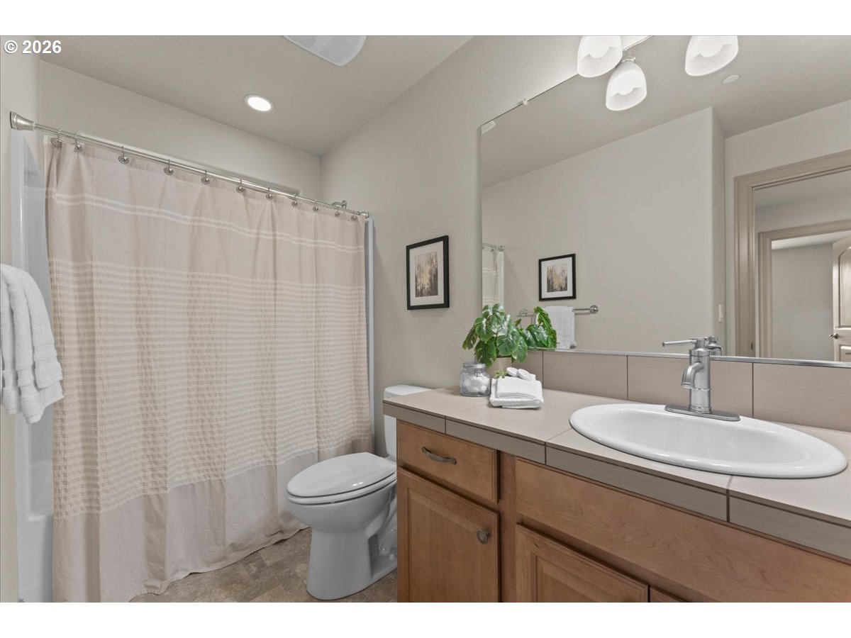 10899 Southwest Barber Street Wilsonville, OR 97070 - Photo 27 of 44 a bathroom with a granite countertop sink a toilet and a mirror