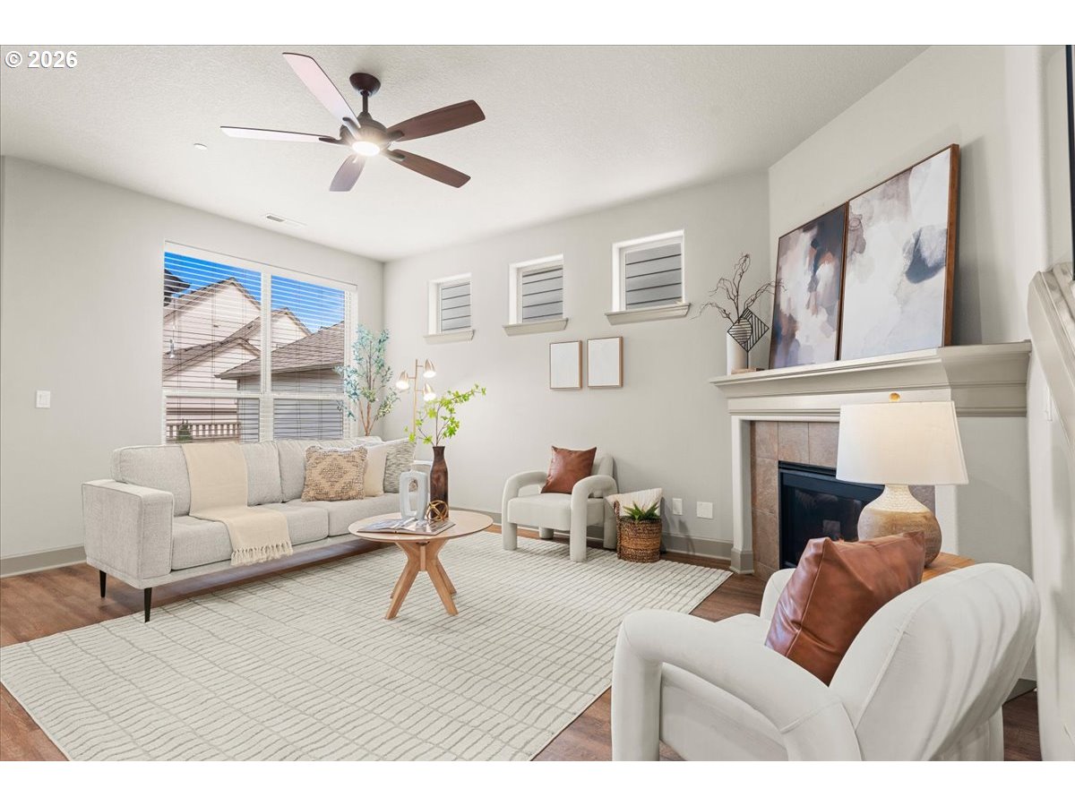 10899 Southwest Barber Street Wilsonville, OR 97070 - Photo 7 of 44 a living room with furniture a large window and a fireplace